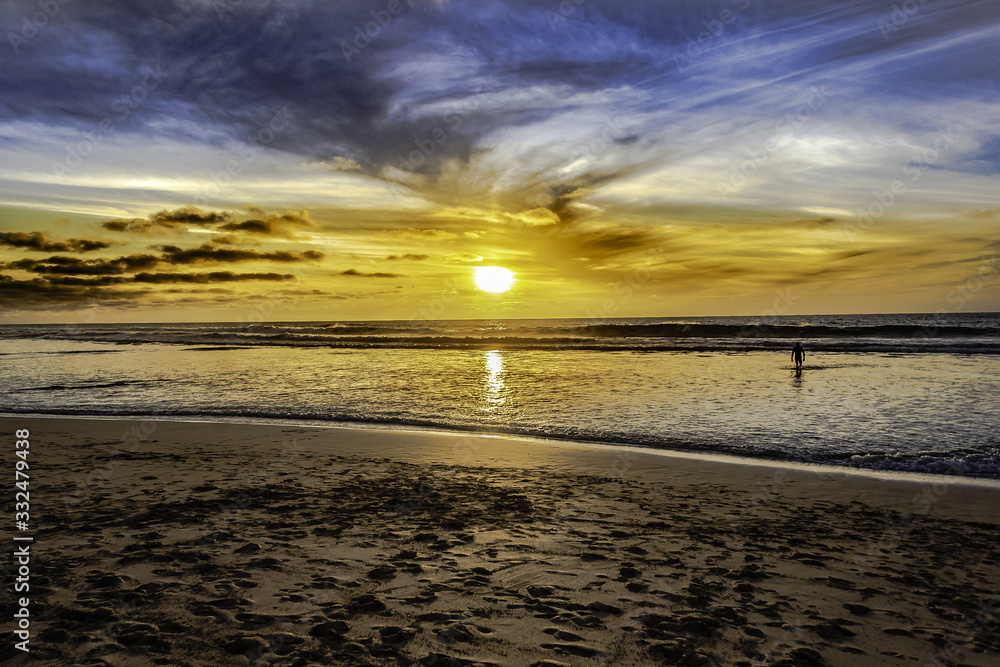 silueta en la playa en atardecer con cielo dorado en una playa silueta en la playa en atardecer con cielo dorado en una playa