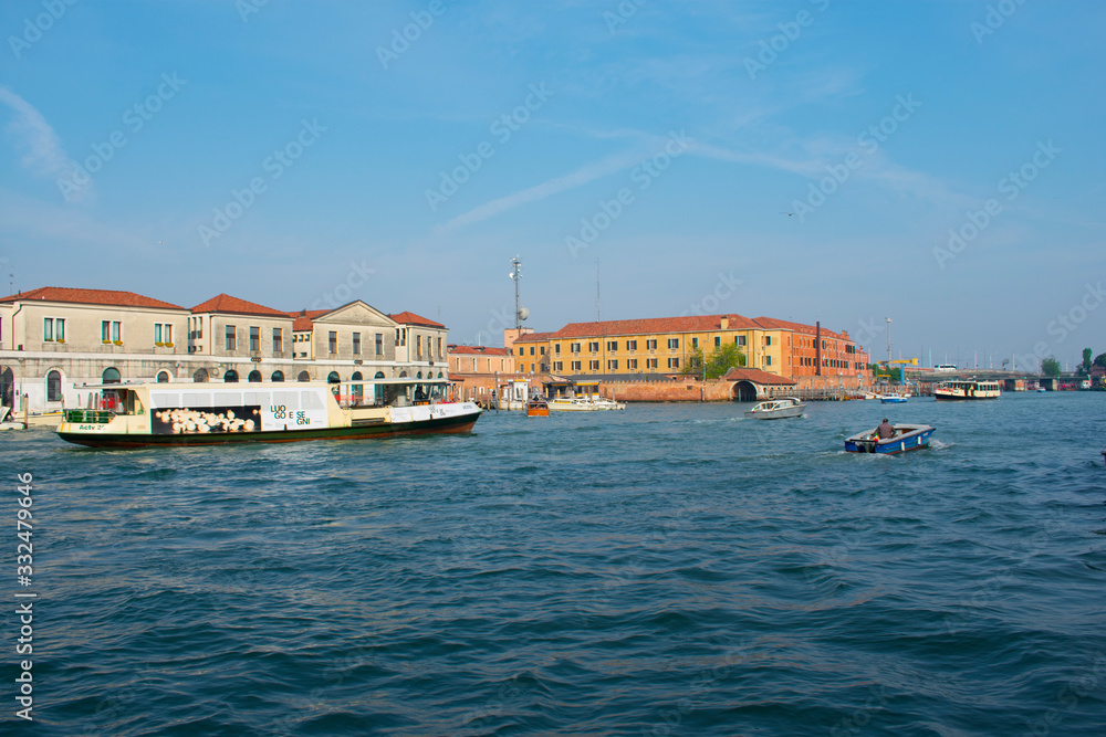 San Marco / Venice / Italy - April 17, 2019: View of canal with tourists in boat and old colorful buildings