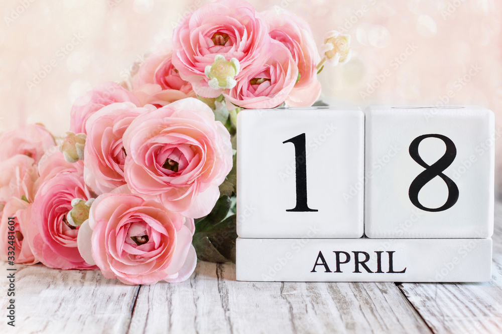 Fototapeta premium White wood calendar blocks with the date April 18th. Selective focus with blurred background.