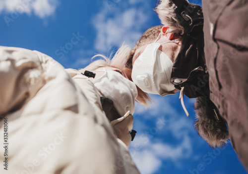 couple in love in protective masks against the blue sky