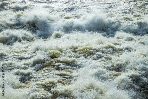 Splashing water waves on the spring fast river photo