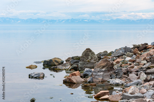 Lake Baikal shore with boulders and mountains on the horizon