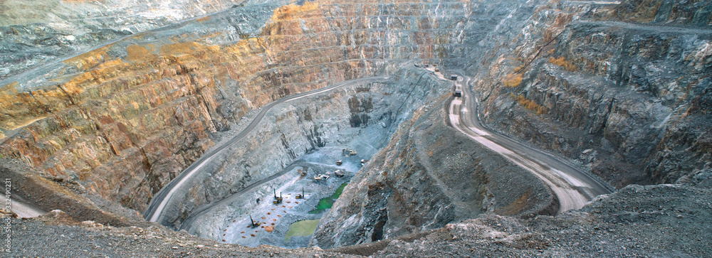 In the gold mine,  a large yellow truck carrying gold ore to the processing machine, panorama view