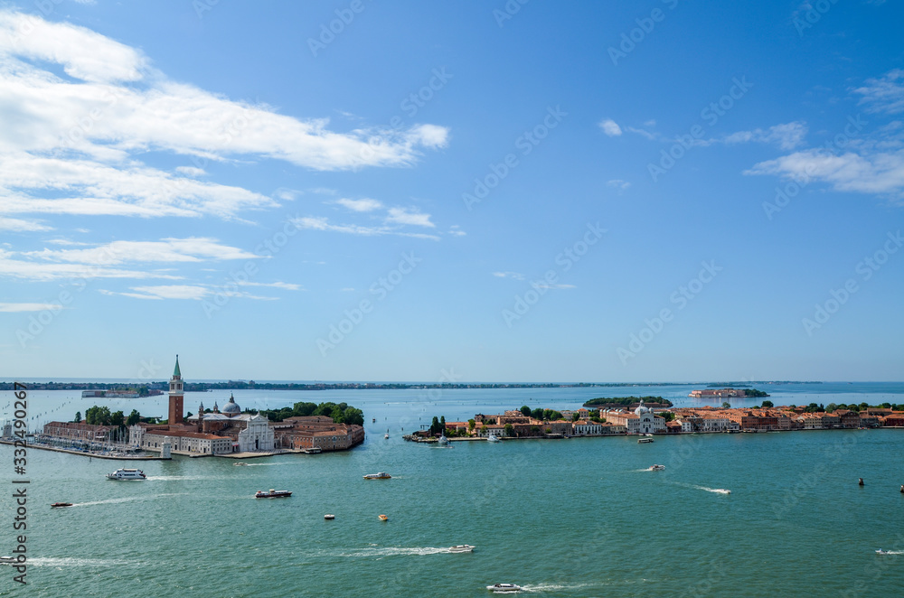 Venice, beautiful aerial view on San Giorgio Maggiore island in the Venetian Lagoon on a clear day. View from the San Marco Campanile. Ships and small boats surround the historic buildings.