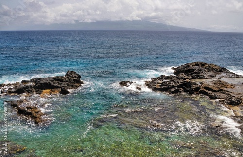 From the shores of the islet of Djeu, the island of Brava sits at sea in the horizon under the clouds