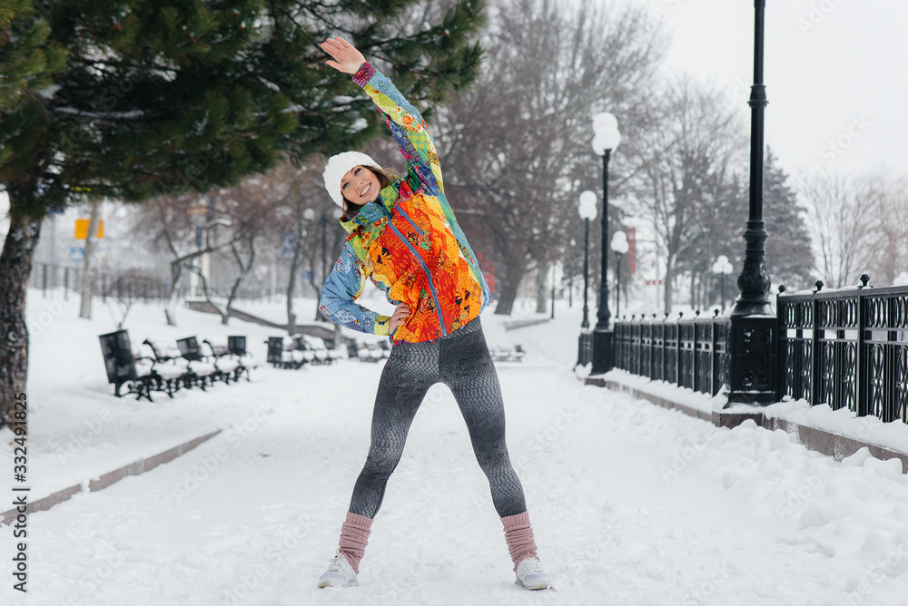 A young athletic girl does sports on a frosty and snowy day. Fitness, running