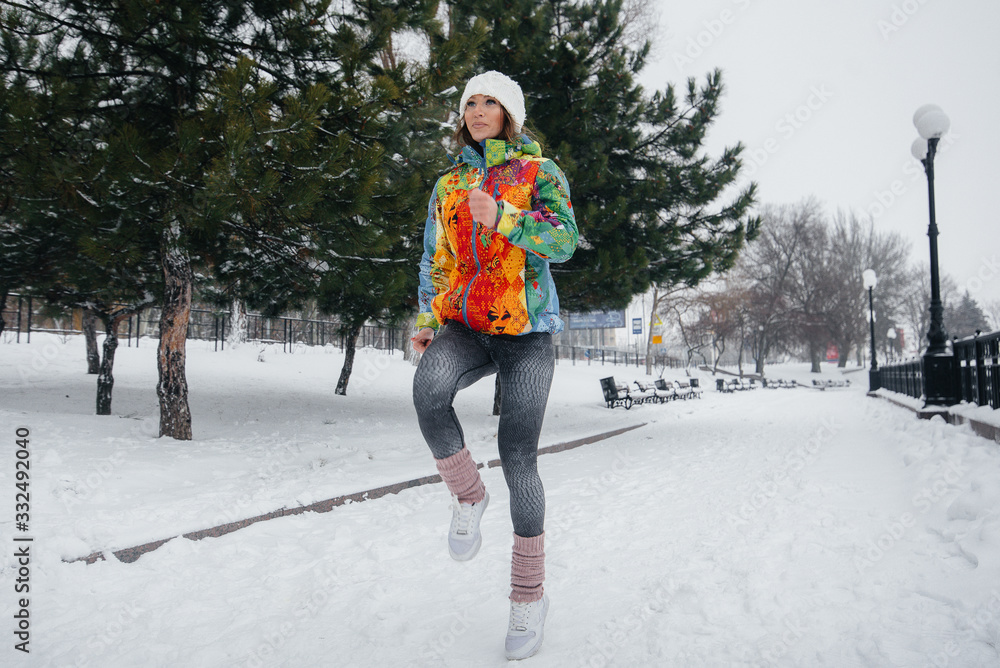 A beautiful young girl is Jogging on a frosty and snowy day. Sports, healthy lifestyle