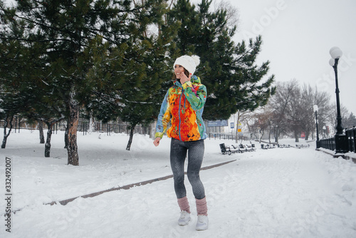 A beautiful young girl is Jogging on a frosty and snowy day. Sports, healthy lifestyle