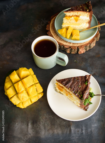 Two pieces of delicious cake with mango, a cup of fragrant tea. View from above.