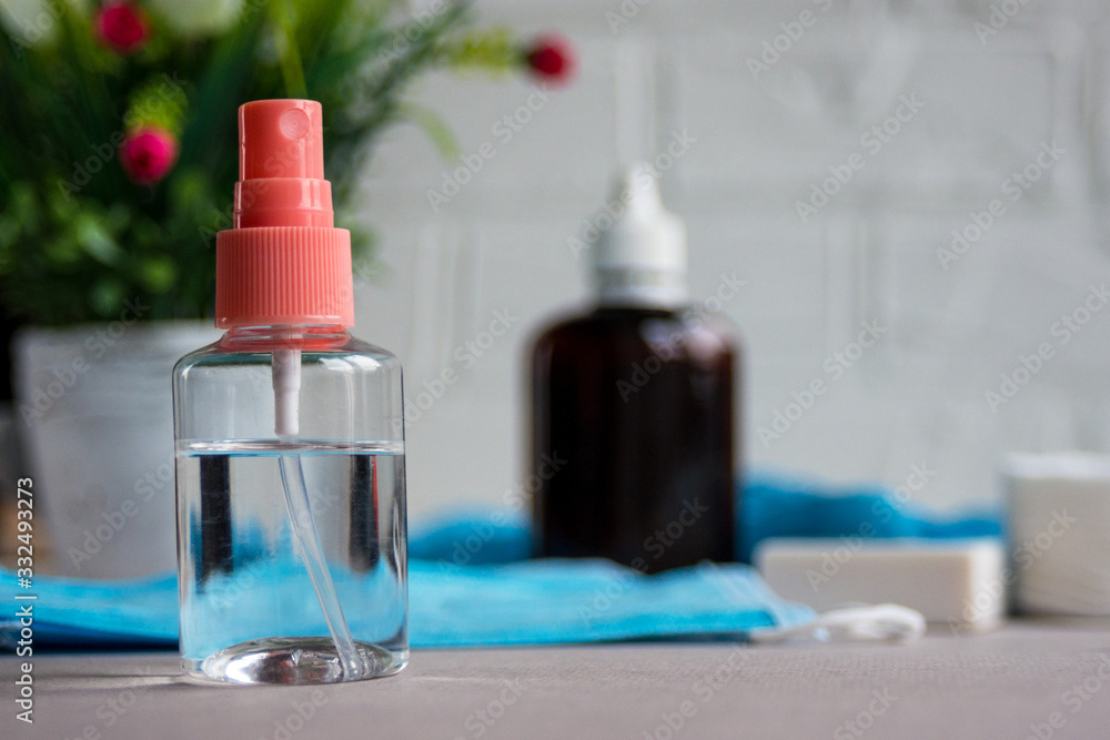 Antibacterial antiseptic in a transparent bottle on the background of protective medical masks and gloves. The concept of prevention and protection against viruses and diseases. Antibacterial antiseptic in a transparent bottle on the background of protective medical masks and gloves. The concept of prevention and protection against viruses and diseases.