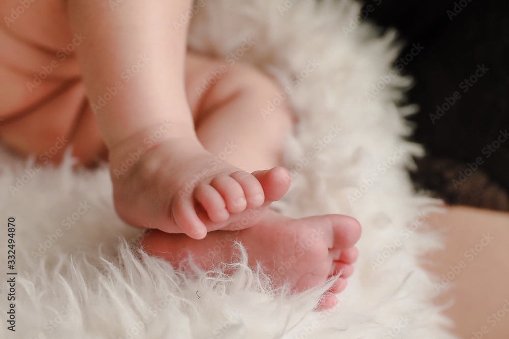 Cute baby feet on a fluffy cream blanket Cute baby feet on a fluffy cream blanket