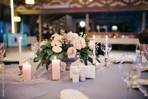 Tenderly decorated wedding table with flowers  glasses and candles in candlesticks