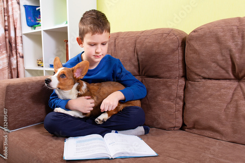 a child reads a book with his dog