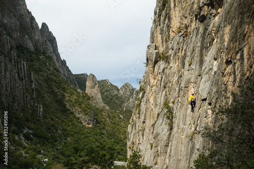 Rock climber scaling a mountain in a Mexican valley.