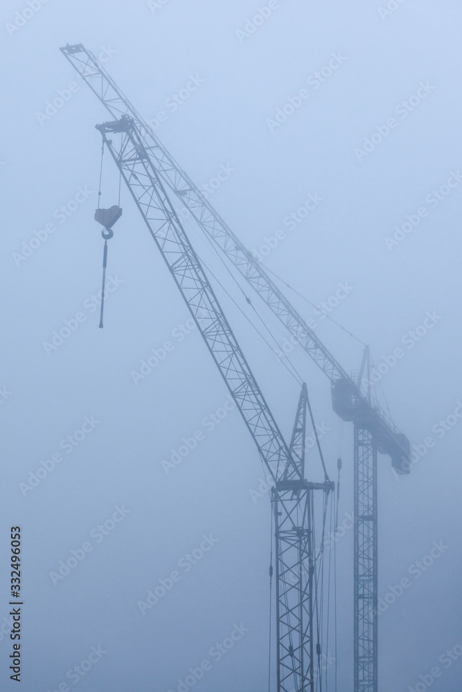 view of construction cranes in the fog view of construction cranes in the fog