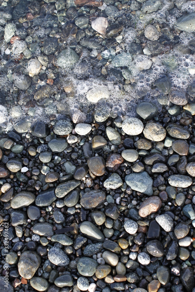 Multi shades of grey pebble with tidal waters and bubbles. 