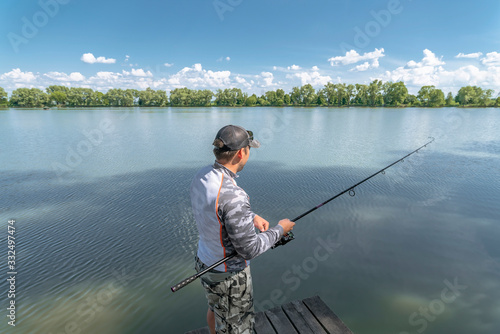 Fishing. Fisherman in action catch fish at lake pond