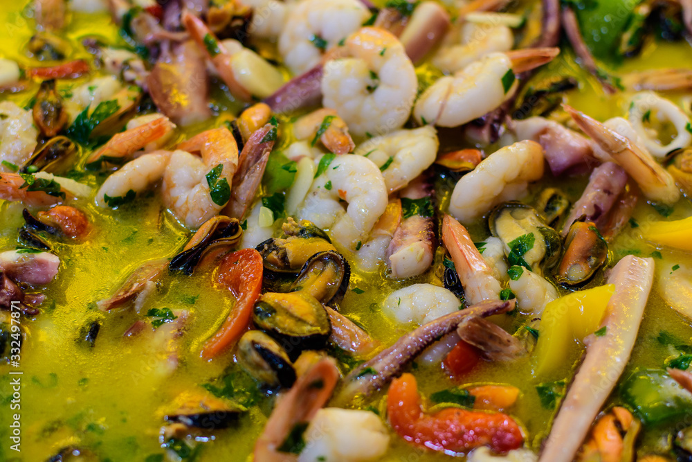Close up of large portion of mixed seafood cooked with vegetables, available for sale at a street food market, top view or flat lay photo of healthy food photographed with selective focus Close up of large portion of mixed seafood cooked with vegetables, available for sale at a street food market, top view or flat lay photo of healthy food photographed with selective focus
