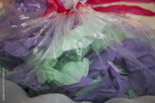 close-up on a transparent trash bag with purple and green tissues to recycle