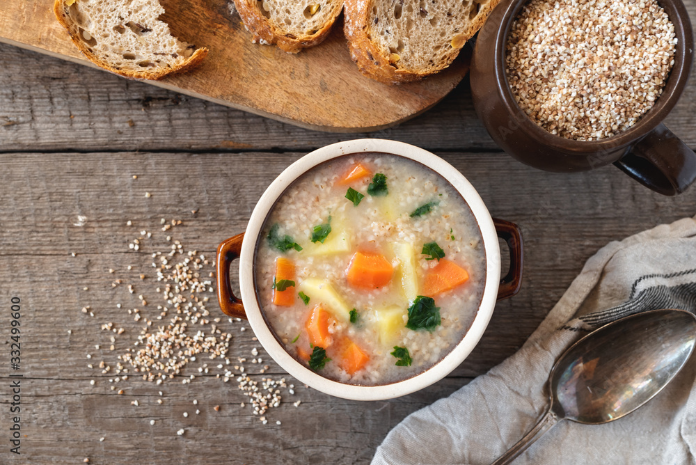 Krupnik, polish barley soup with vegetables on a wooden background Krupnik, polish barley soup with vegetables on a wooden background