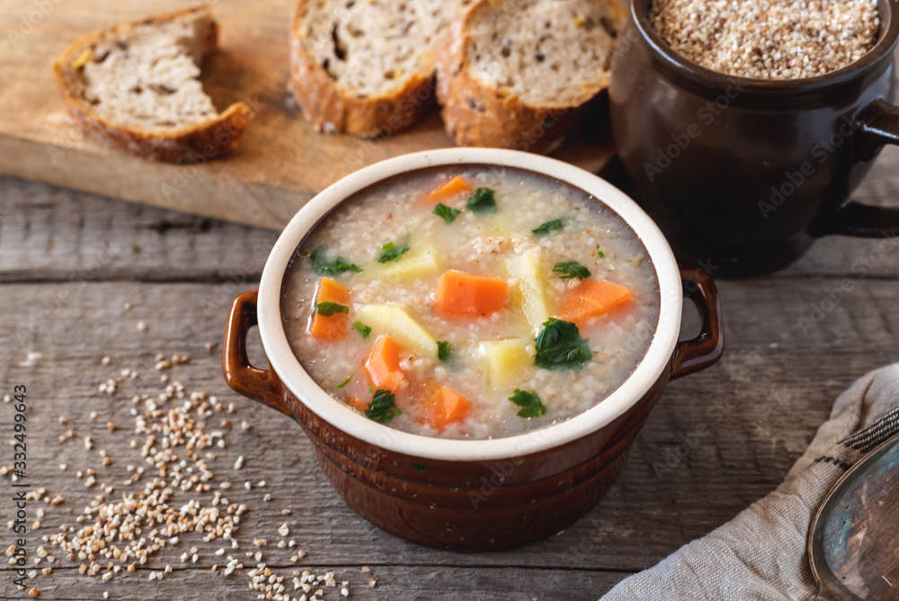 Krupnik, polish barley soup with vegetables on a wooden background