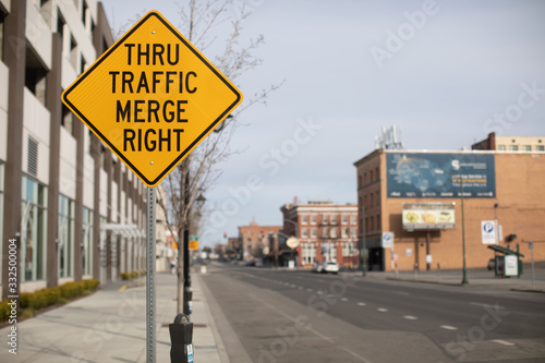 Thru traffic merge right yellow traffic sign on city street © Crystal Madsen