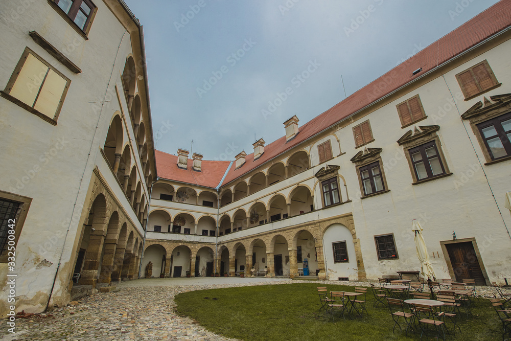 Beautiful courtyard with arches of the Ptuj castle. Facade and main square of Ptujski grad on a dull autumn day.