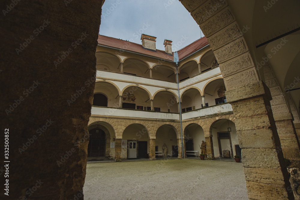 Beautiful courtyard with arches of the Ptuj castle. Facade and main square of Ptujski grad on a dull autumn day.