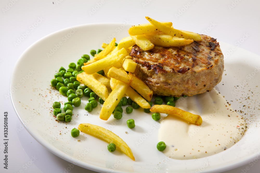 Appetizing chop (cutlet) with fries isolated on white background. Grilled meat Appetizing chop (cutlet) with fries isolated on white background. Grilled meat