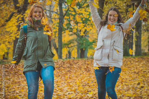 Photography Two women throwing autumn leaves in the air in romantic forest