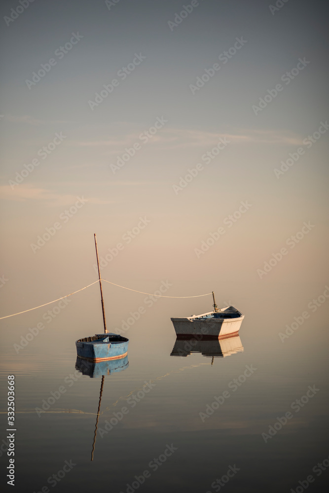 Still boats over pastel sky and empty calm ocean on the seaside Still boats over pastel sky and empty calm ocean on the seaside