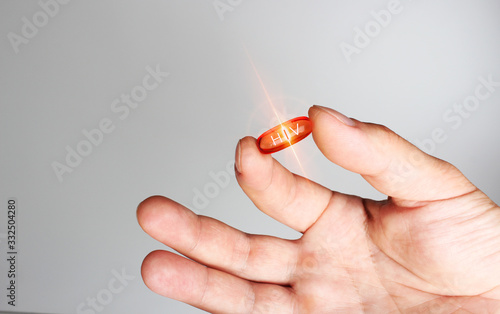 red capsule hiv medicine in hand lettering photo