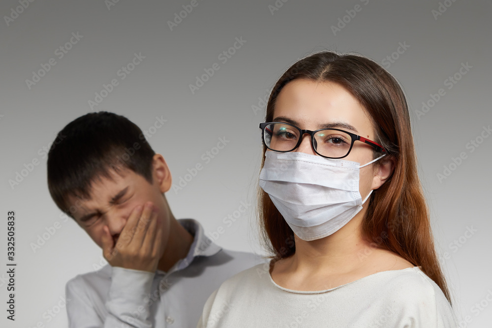masked girl and boy sneezing, the concept of protection against the spread of the virus medical mask masked girl and boy sneezing, the concept of protection against the spread of the virus medical mask