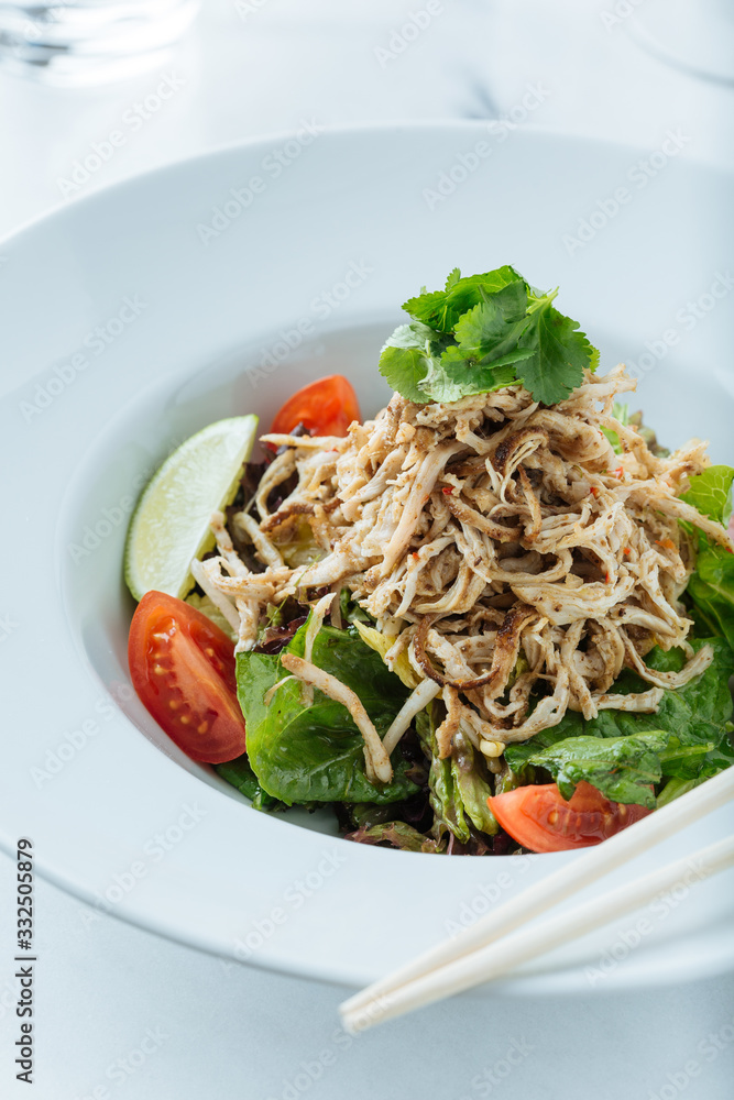 From above of fresh salad of tomatoes lime and lettuce served with cuts of meat and parsley in restaurant From above of fresh salad of tomatoes lime and lettuce served with cuts of meat and parsley in restaurant