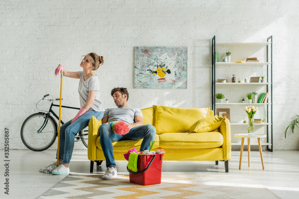 tired man and woman sitting on sofa near household tired man and woman sitting on sofa near household