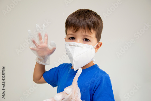 Caucasian boy wearing mask and surgical gloves with gesturing with his hands protecting himself from respiratory diseases. Face mask to protect against outbreaks of coronavirus, covid-19, virus, disea photo