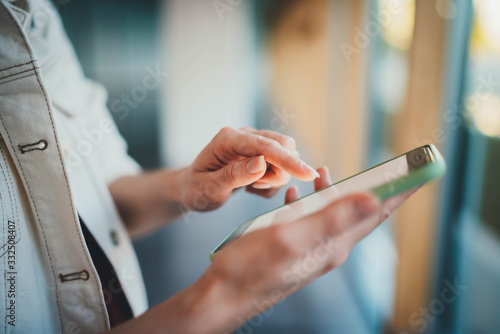 Side view of female hands using cellphone device typing text message during coffee break  Communication Business People Concept  Young hipster student girl chatting with friends while in a museum