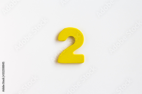 yellow painted wooden number two, craft sign for kid's education isolated, ecological concept