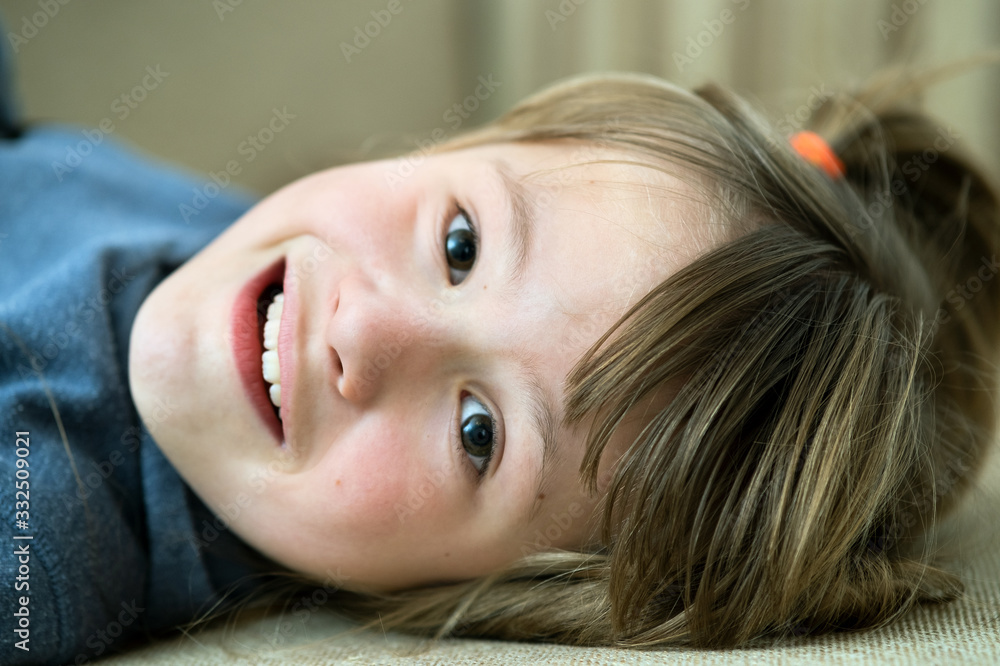 Portrait of a pretty child girl laying down at home. Portrait of a pretty child girl laying down at home.