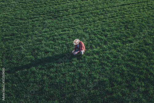 Tableau sur toile Wheat farmer using drone remote controller in wheatgrass field, aerial