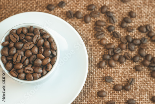 Cup of coffee beans. Coffee beans scattered around