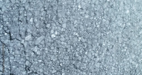 Flying over frozen lake. Melting ice aerial view. Ice Pattern. 