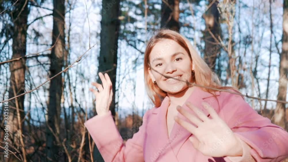 Beautiful smiling woman walking throught tree branches in forest. Attractive stylish girl outdoors enjoying sunrays and forest. Beautiful smiling woman walking throught tree branches in forest. Attractive stylish girl outdoors enjoying sunrays and forest.