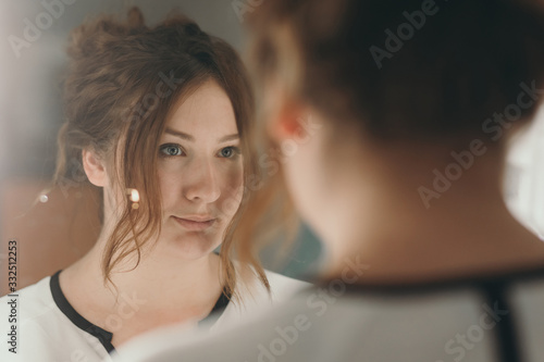 Cuadro en lienzo Woman looking in the mirror admiring herself