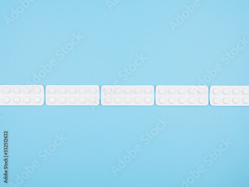 The dotted line of blisters of pills on a blue background.