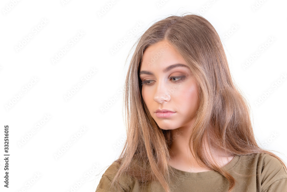Pretty young girl with long brunette hair looks at camera with doubt over white background Pretty young girl with long brunette hair looks at camera with doubt over white background