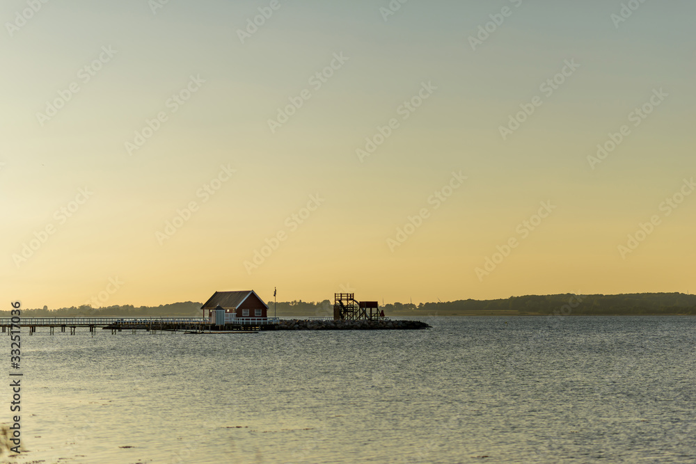 Einsames Haus am Wasser bei Sonnenaufgang