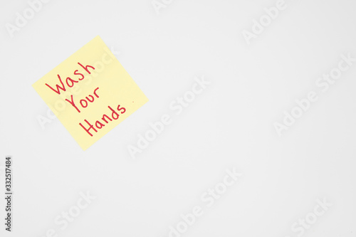Wash your hands reminder on a sticky note in bold red letters