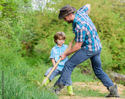 Find treasures. Little boy and father with shovel looking for treasures. Happy childhood. Adventure hunting for treasures. Little helper in garden. Cute child in nature having fun with cowboy dad