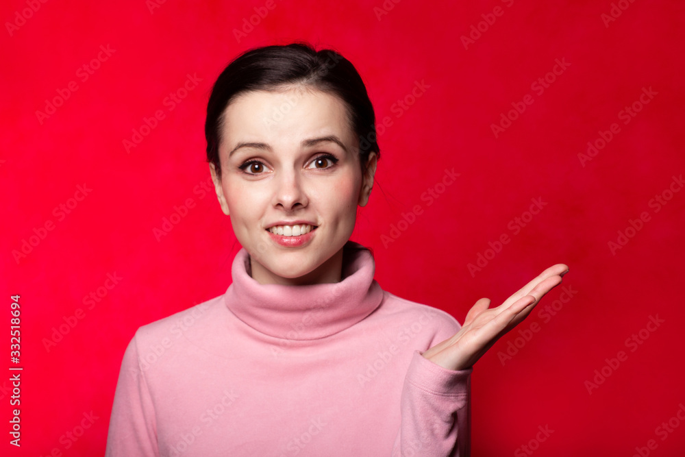 beautiful girl in a pink turtleneck talking on the phone on a red background beautiful girl in a pink turtleneck talking on the phone on a red background